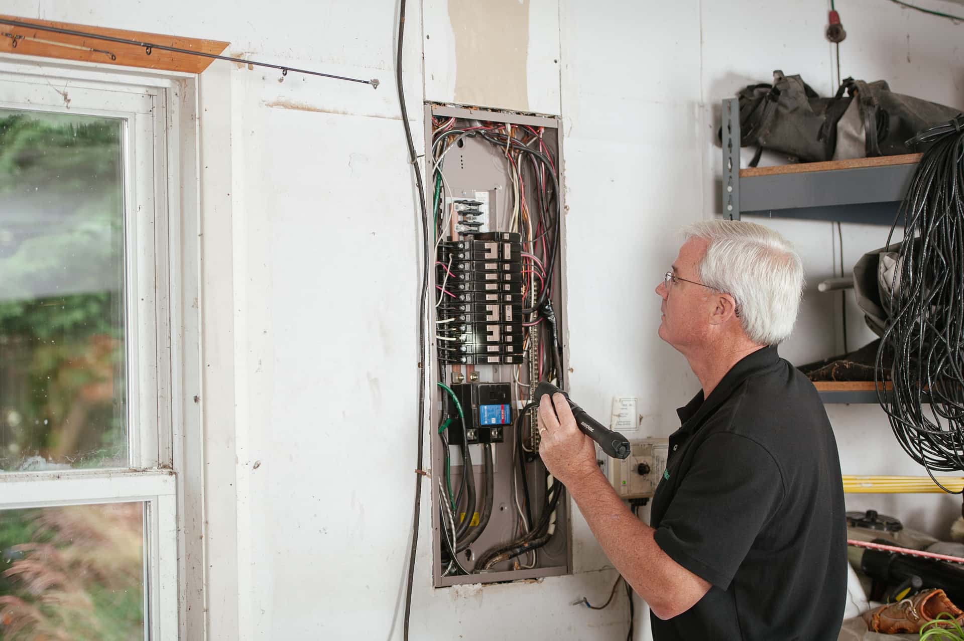 An electrician wiring a 240-volt circuit for an EV charger